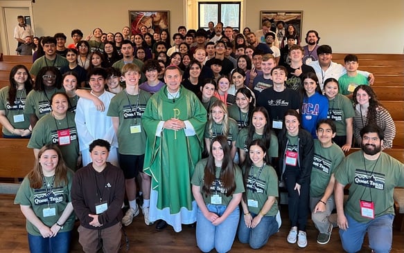 a whole group of students together with their priest in a church