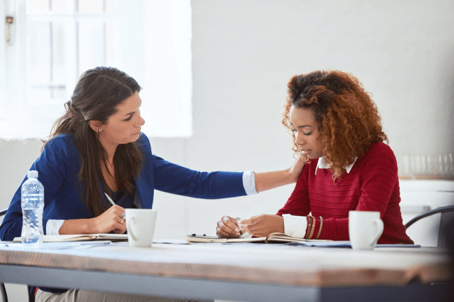 women comforting another women at a table